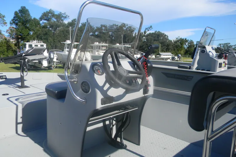 Slide: The Image of 2025 SeaArk Shadow 18 t boat console with steering wheel and controls, docked outdoors. - 3