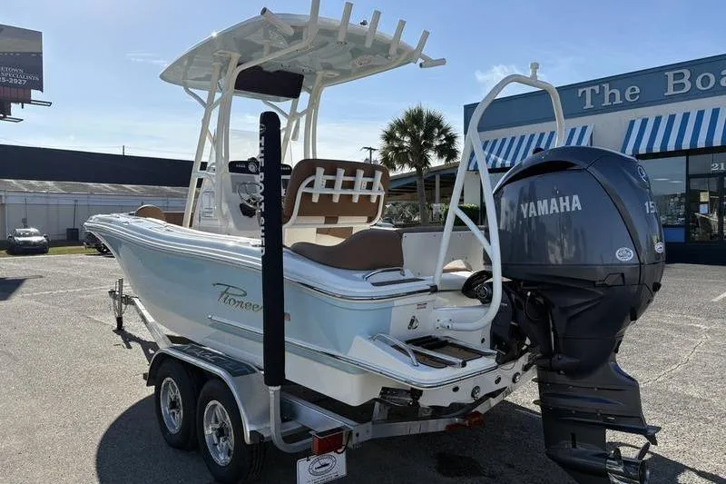 Slide: The Image of 2025 Pioneer 202 Islander boat with Yamaha engine on trailer, parked outside dealership. - 1