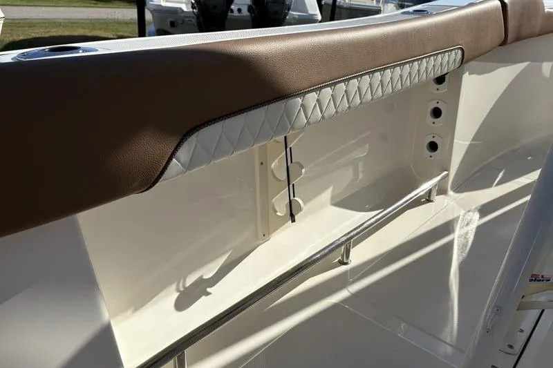 Slide: The Image of 2025 Pioneer 202 Islander boat interior with brown and white cushioned seating detail. - 12