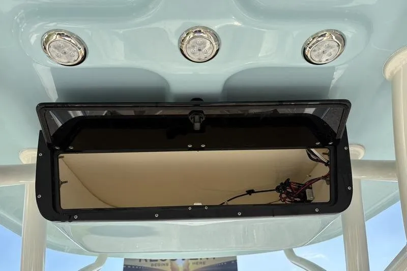 Slide: The Image of 2025 Pioneer 202 Islander boat with open storage compartment and overhead lights. - 16