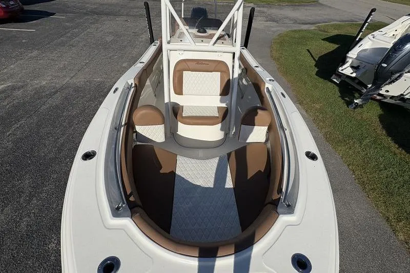 Slide: The Image of 2025 Pioneer 202 Islander boat interior with tan and white seating, parked on pavement. - 27