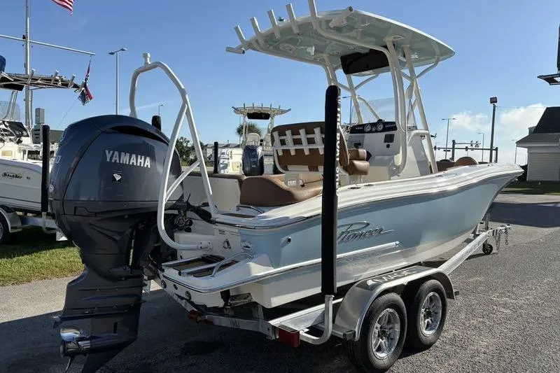 Slide: The Image of 2025 Pioneer 202 Islander boat with Yamaha engine on a trailer, parked outdoors. - 3