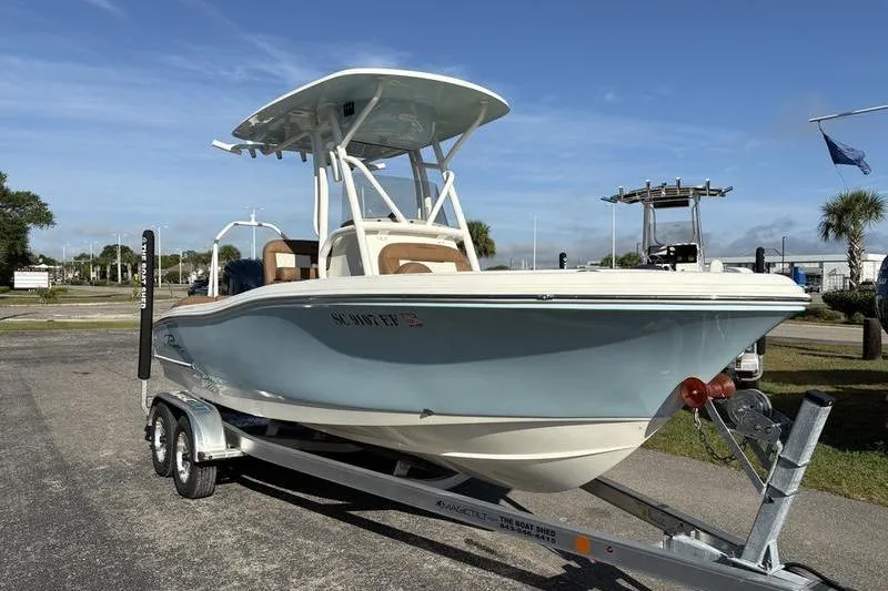 Slide: The Image of 2025 Pioneer 202 Islander boat on trailer, parked outdoors under clear sky. - 5
