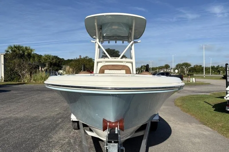 Slide: The Image of 2025 Pioneer 202 Islander boat on trailer, parked outdoors under clear sky. - 6