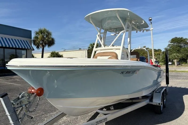 Slide: The Image of 2025 Pioneer 202 Islander boat on trailer, parked outdoors under clear sky. - 7