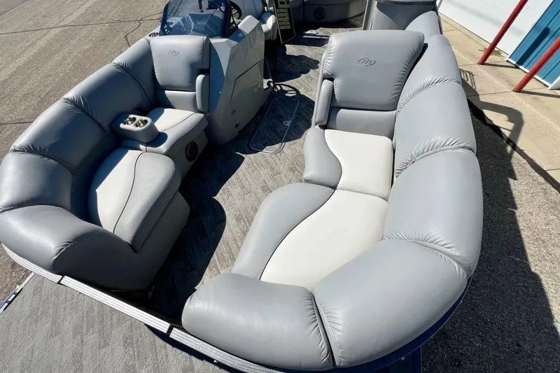 Slide: The Image of 2018 Manitou MD 25 TriToon boat interior with plush gray seating and console. - 19