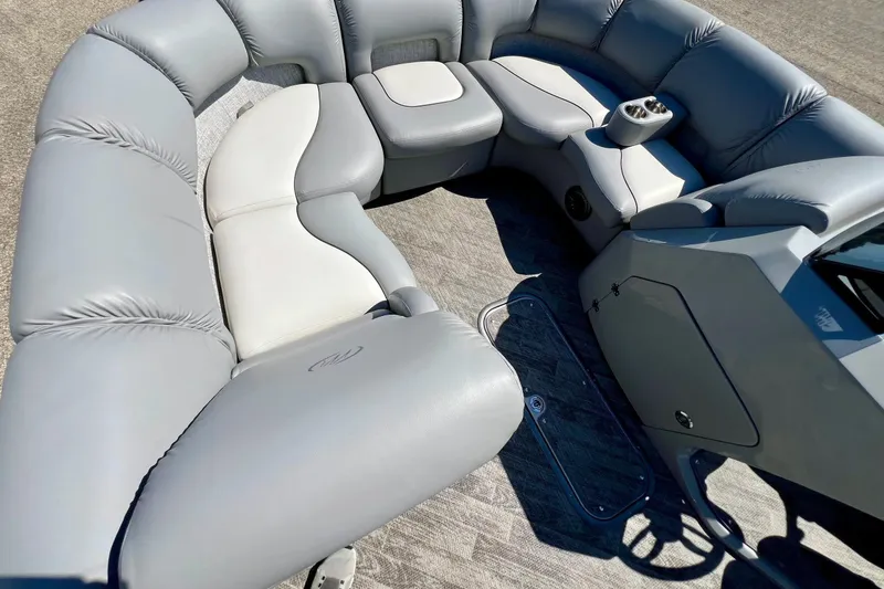 Slide: The Image of 2018 Manitou MD 25 TriToon boat interior with plush gray seating and cup holders. - 23