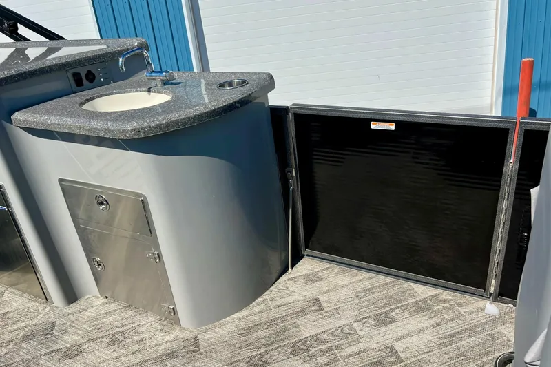 Slide: The Image of 2018 Manitou MD 25 TriToon boat interior with sink and storage compartments. - 25