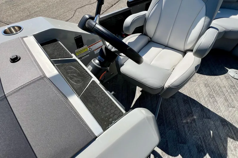 Slide: The Image of 2018 Manitou MD 25 TriToon boat interior with steering wheel and captain's chair. - 27