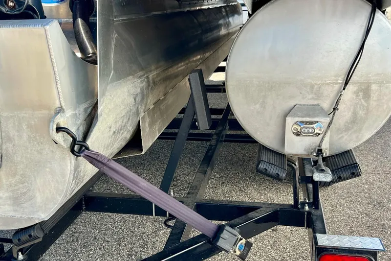 Slide: The Image of 2018 Manitou MD 25 TriToon pontoon boat on trailer, secured with straps. - 30