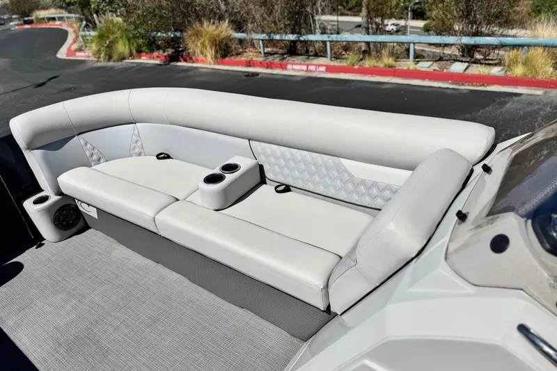 Slide: The Image of 2022 Crest Classic DLX 240 SLRC boat interior with plush seating and cup holders. - 11