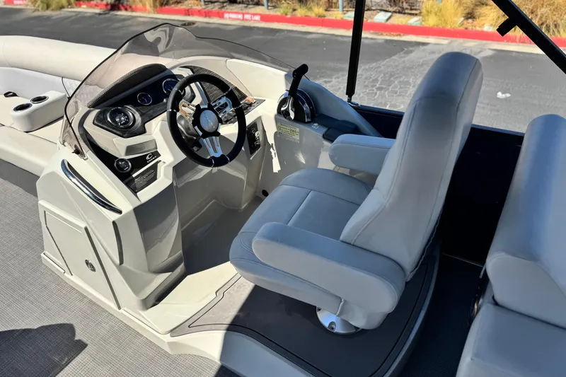 Slide: The Image of 2022 Crest Classic DLX 240 SLRC boat interior with steering wheel and captain's chair. - 19