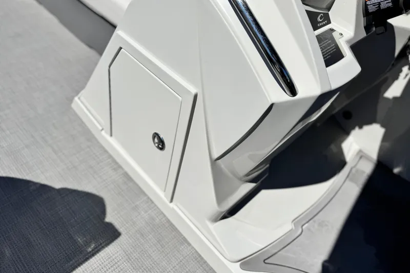 Slide: The Image of 2022 Crest Classic DLX 240 SLRC boat console with storage compartment and sleek design. - 22