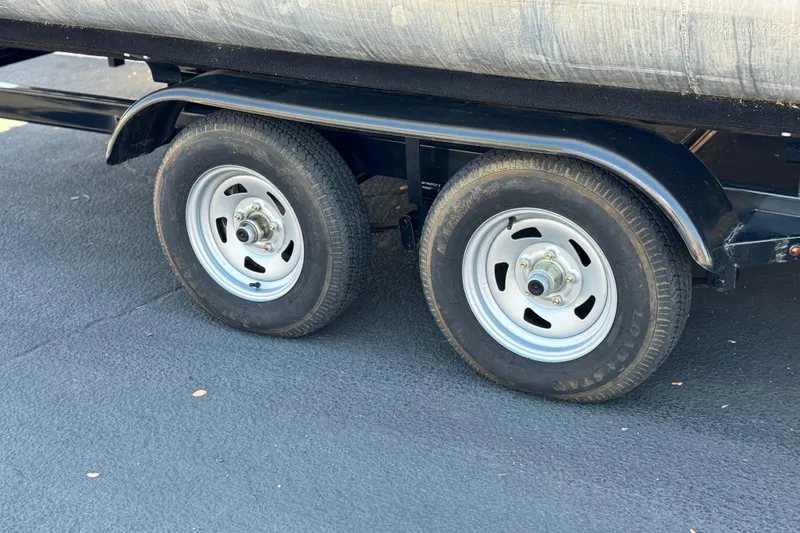 Slide: The Image of Trailer wheels of a 2022 Crest Classic DLX 240 SLRC on asphalt. - 23
