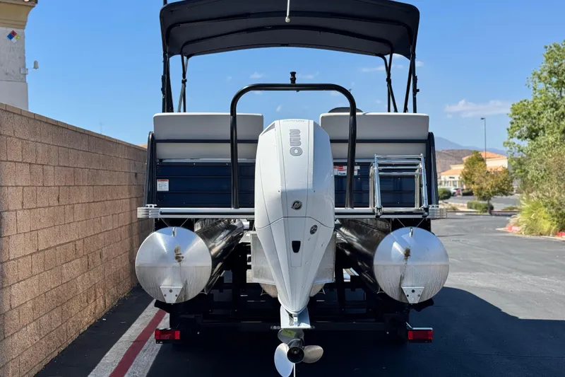 Slide: The Image of 2022 Crest Classic DLX 240 SLRC pontoon boat with outboard motor, parked outdoors. - 5