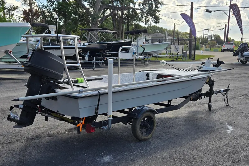 Slide: The Image of 2014 IBP 14 Skiff boat on trailer, parked outdoors with other boats in background. - 3