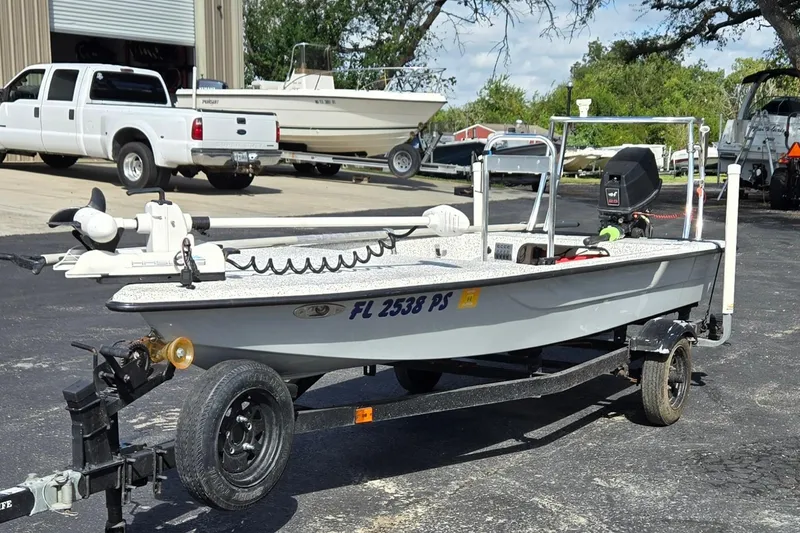 Slide: The Image of 2014 IBP 14 Skiff boat on trailer in parking lot with other vehicles. - 7