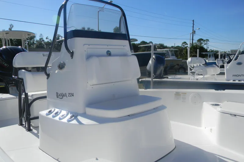 Slide: The Image of 2026 BlackJack 224 boat with sleek white console and seating, displayed outdoors. - 10