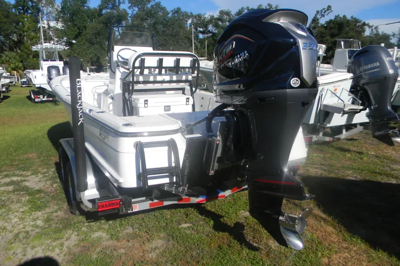 Slide: The Image of 2026 BlackJack 224 boat with Yamaha outboard motor on a trailer, parked on grass. - 16