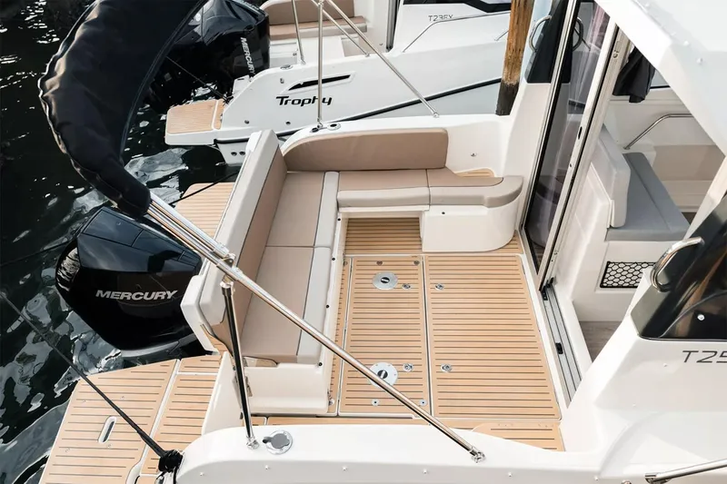 Slide: The Image of 2023 Bayliner Trophy T25 Explorer boat interior with cushioned seating and deck space. - 16