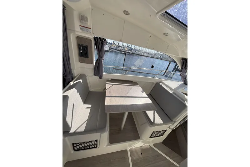 Slide: The Image of 2023 Bayliner Trophy T25 Explorer interior with helm, sink, and window view. - 9