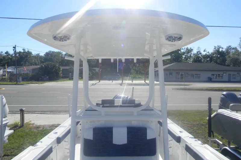 Slide: The Image of Parker 230 Coastal Elite 2026 boat with T-top, parked outdoors in sunlight. - 14