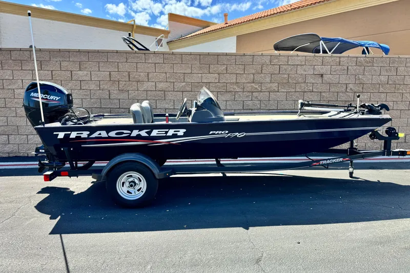The Image of 2022 Tracker Pro 170 boat on trailer, parked outdoors against a brick wall. - 0