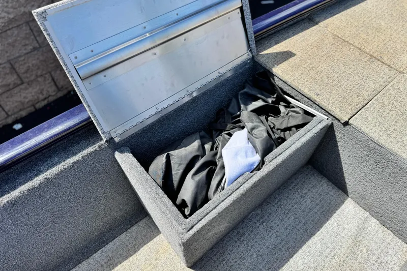 Slide: The Image of Open storage compartment on 2022 Tracker Pro 170 boat with fabric inside. - 14