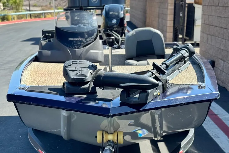 Slide: The Image of 2022 Tracker Pro 170 boat with trolling motor, parked on pavement. - 2