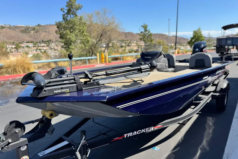 Slide: The Image of 2022 Tracker Pro 170 boat on trailer, featuring Minn Kota trolling motor, parked outdoors. - 3