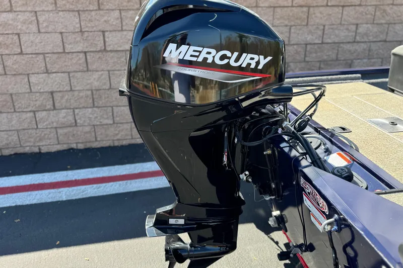 Slide: The Image of 2022 Tracker Pro 170 boat with Mercury outboard motor, parked on pavement. - 6
