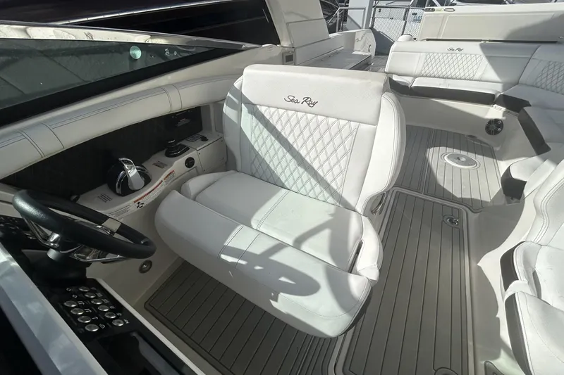 Slide: The Image of 2019 Sea Ray SLX 350 Outboard interior with white seating and steering wheel. - 21