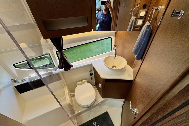 Slide: The Image of 2024 Beneteau Antares 11 bathroom with modern fixtures and wood accents. - 12