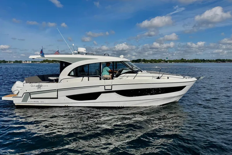 Slide: The Image of 2024 Beneteau Antares 11 cruising on a serene lake under a blue sky. - 19