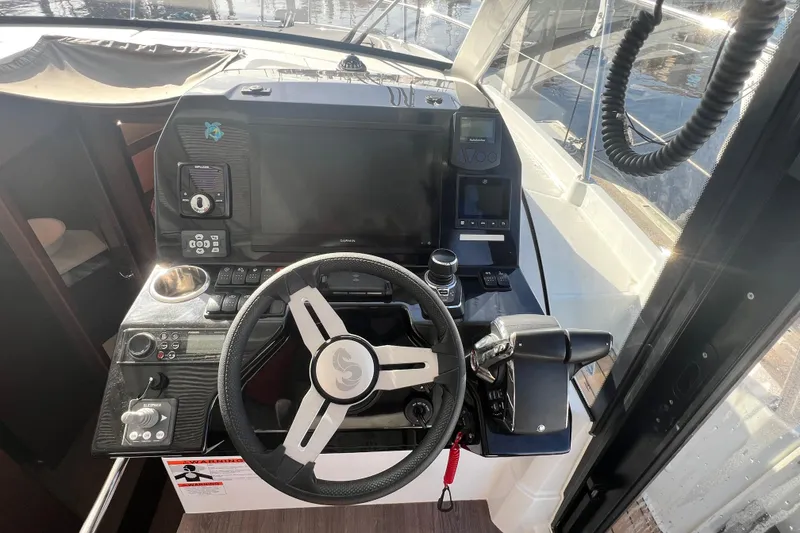 Slide: The Image of Interior view of 2024 Beneteau Antares 11 boat with navigation equipment and marina background. - 24