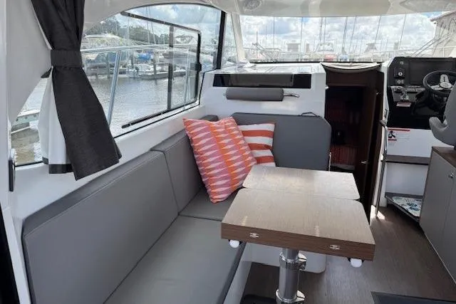Slide: The Image of Interior view of 2024 Beneteau Antares 11 with modern kitchen and window overlooking marina. - 9