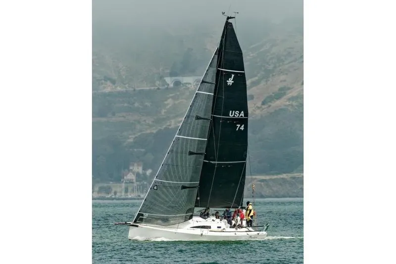 Slide: The Image of 2021 J/Boats J/99 sailing on a misty coastal waterway. - 2