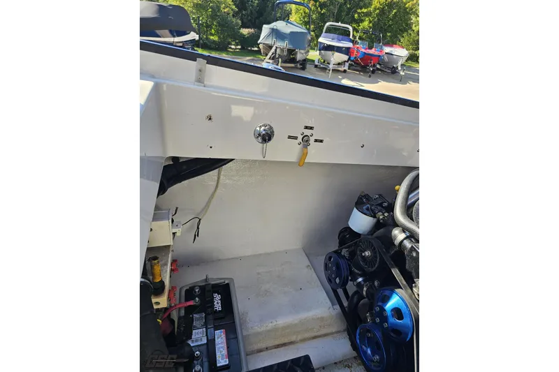 Slide: The Image of 2002 Hustler 388 SLINGSHOT engine compartment with visible battery and mechanical components. - 104