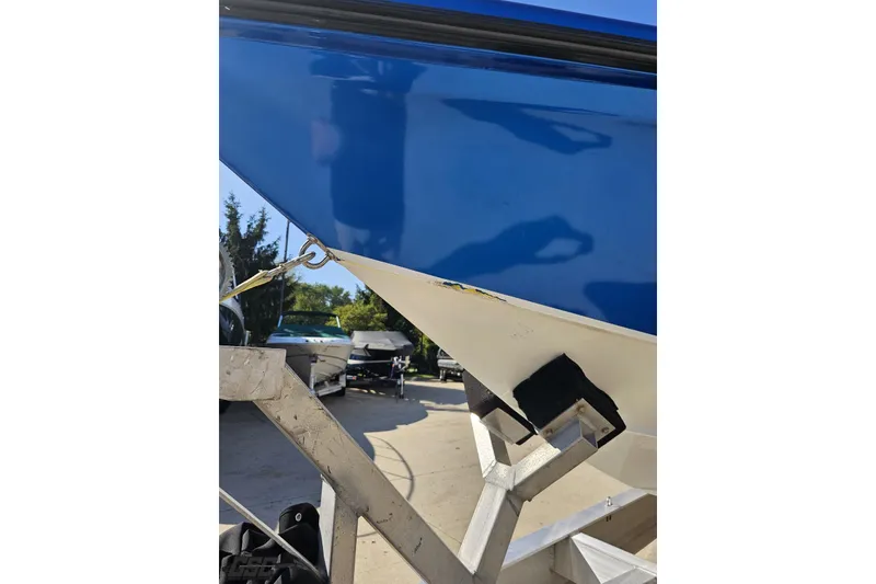 Slide: The Image of 2002 Hustler 388 SLINGSHOT boat on trailer, showing blue hull and bow detail. - 20