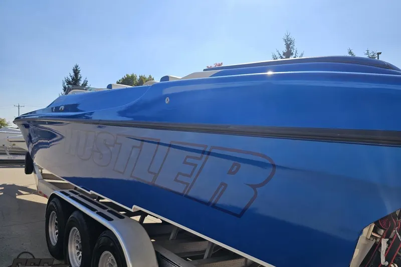Slide: The Image of Blue 2002 Hustler 388 SLINGSHOT boat on trailer, side view. - 32