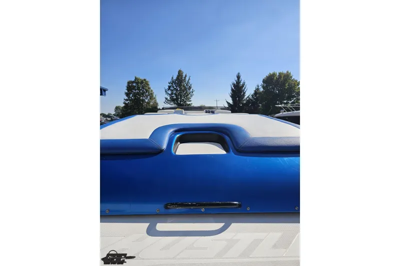 Slide: The Image of 2002 Hustler 388 SLINGSHOT boat, blue and white exterior, sunny day, trees in background. - 42