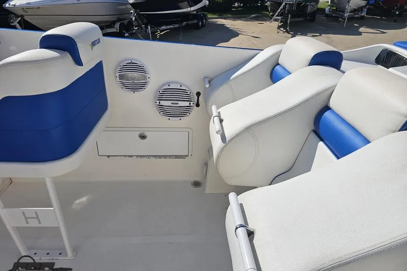 Slide: The Image of Interior of a 2002 Hustler 388 SLINGSHOT boat with blue and white seating. - 52