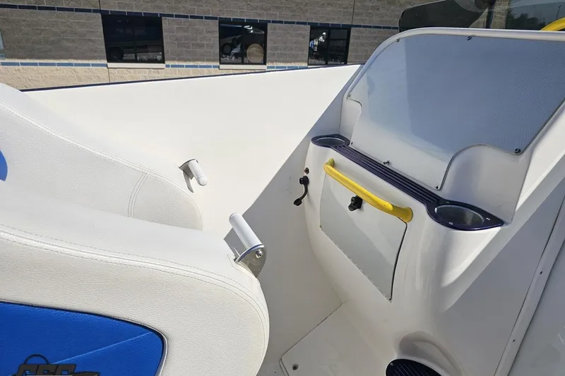 Slide: The Image of 2002 Hustler 388 SLINGSHOT boat interior with white and blue seating, dashboard, and yellow handle. - 53