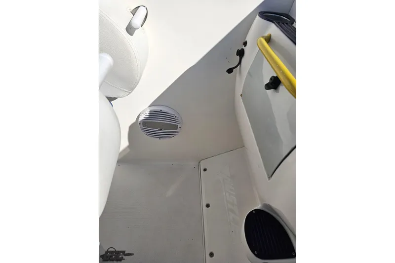 Slide: The Image of Interior of 2002 Hustler 388 SLINGSHOT boat, featuring white seating and speaker. - 54
