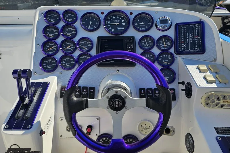 Slide: The Image of Dashboard of a 2002 Hustler 388 SLINGSHOT with purple steering wheel and gauges. - 57