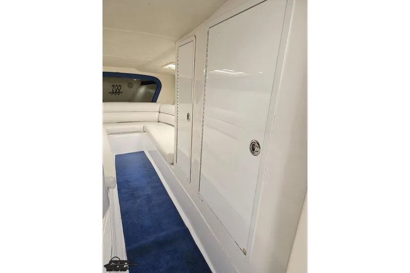 Slide: The Image of Interior of 2002 Hustler 388 SLINGSHOT boat with white seating and blue carpet. - 67