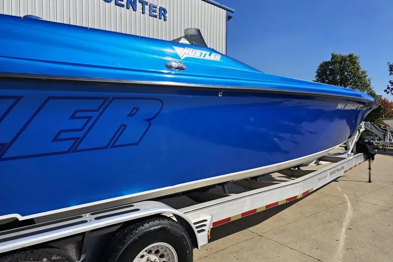 Slide: The Image of 2002 Hustler 388 SLINGSHOT boat in vibrant blue on a trailer. - 7