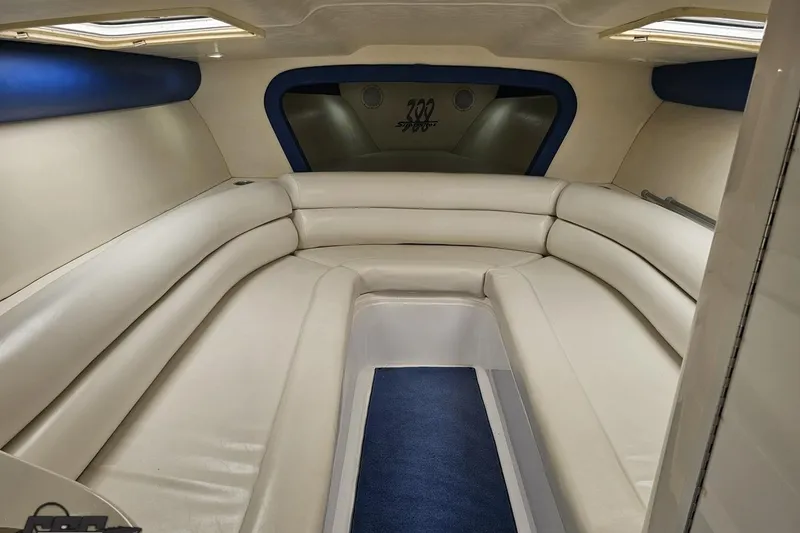 Slide: The Image of Interior of 2002 Hustler 388 SLINGSHOT boat with white leather seating and blue accents. - 74