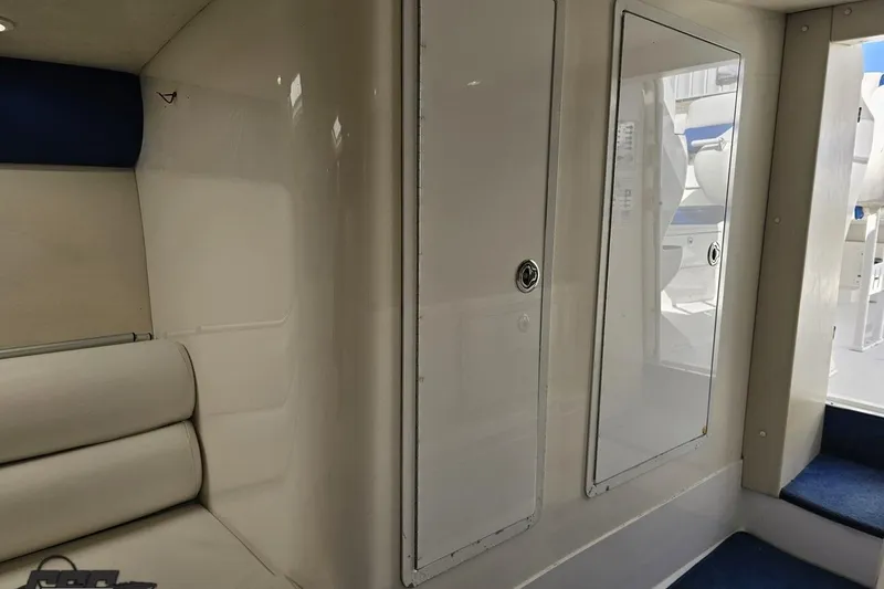 Slide: The Image of Interior of 2002 Hustler 388 SLINGSHOT boat with white seating and storage compartments. - 78