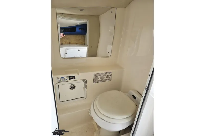 Slide: The Image of Compact bathroom inside 2002 Hustler 388 SLINGSHOT boat, featuring toilet and mirror. - 80
